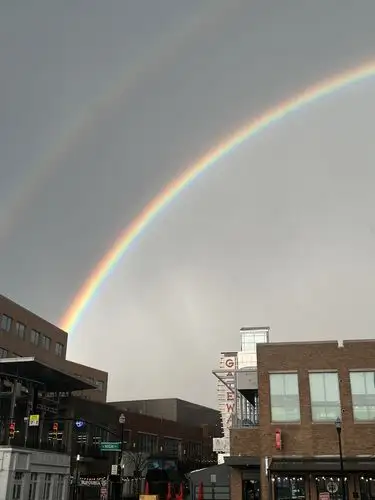 Urban magic unfolds beneath a vibrant double rainbow.